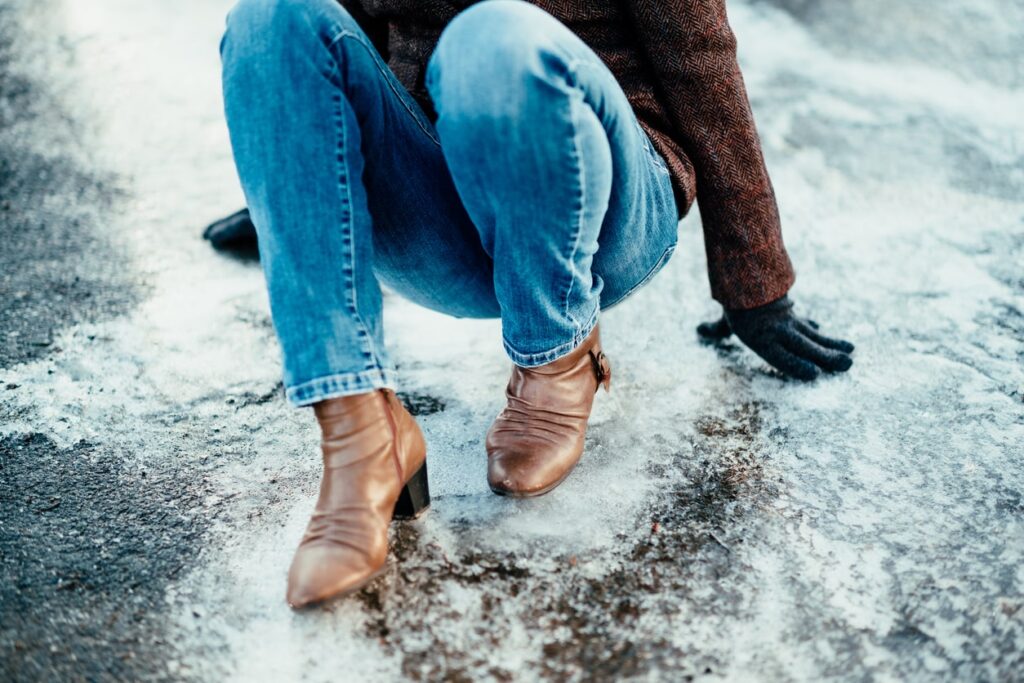 Woman fallen down on icy street in winter.