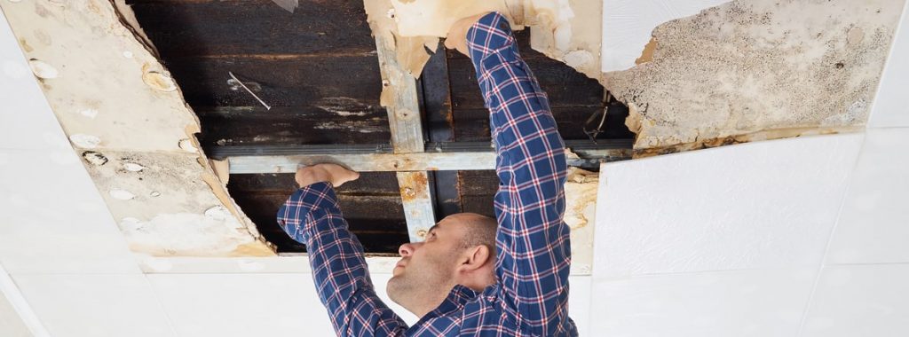 Man repairing collapsed ceiling.